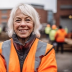 Old female worker with grey hair smiling on a building site