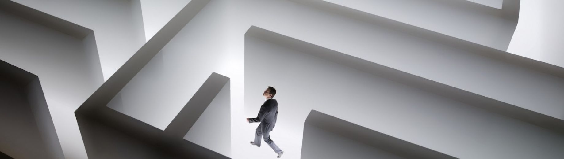 Graphic of a man in a suit walking around a maze
